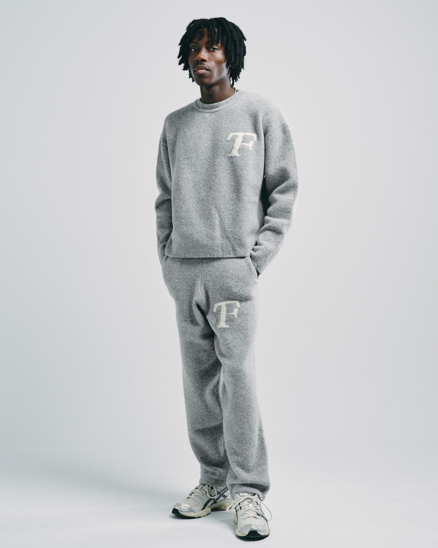 Model styled in light grey knitted joggers, perfect for casual everyday wear or lounging.