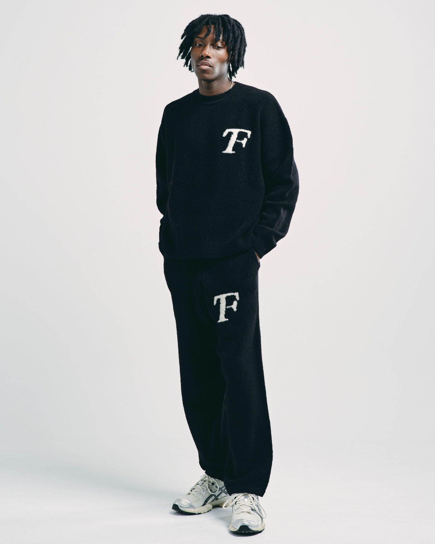 Model wearing black knitted joggers, styled for a casual yet elevated everyday look.