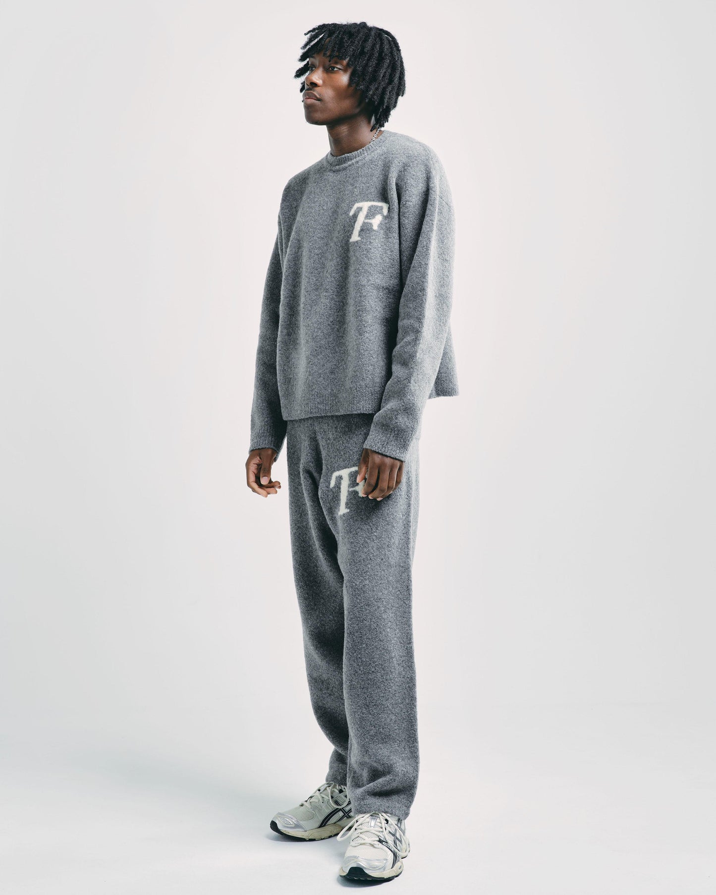 Model wearing dim grey knitwear sweater and matching knitted joggers, styled casually for a versatile and modern look.