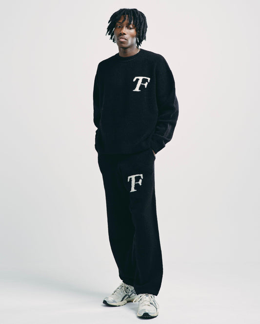 Model wearing black knitted joggers, styled for a casual yet elevated everyday look.