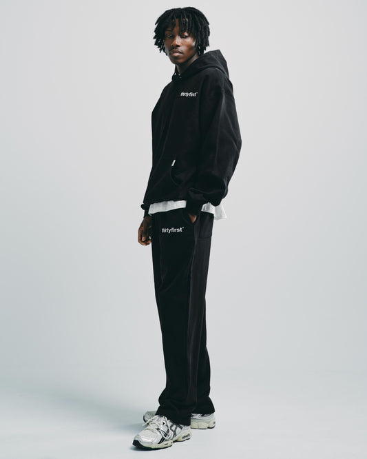 Model styled in black cotton tracksuit bottoms, perfect for a casual or sporty everyday look.